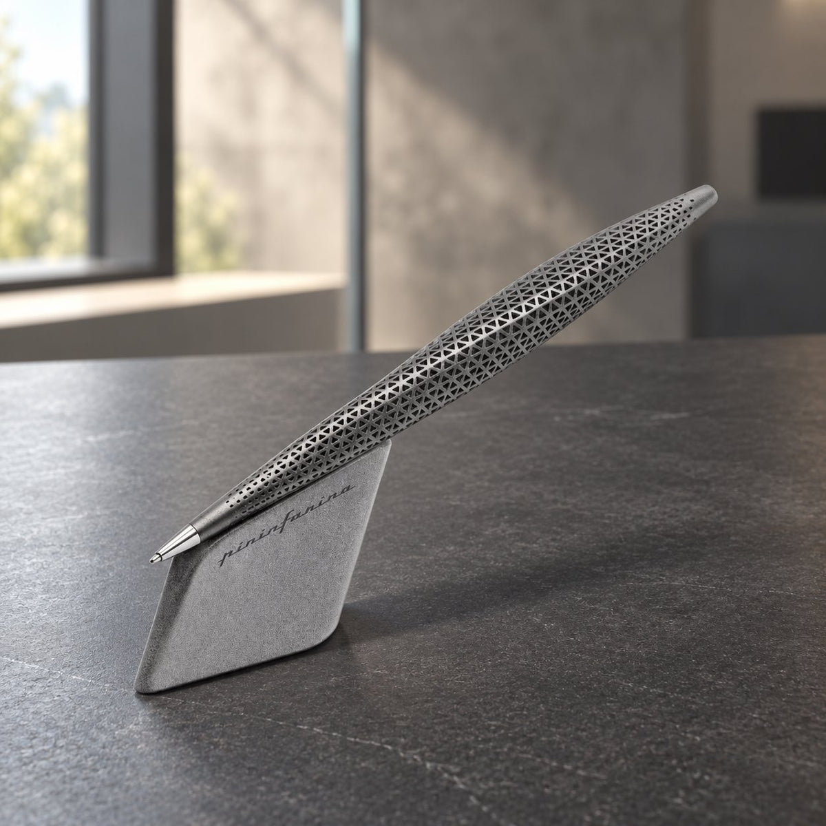 Pininfarina Speedform Ink Titanium con base magnetica su scrivania in pietra scura